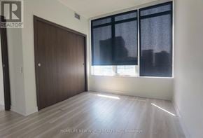 Toronto (Waterfront Communities) condo for rent - A room with a wooden door and a window with blinds.