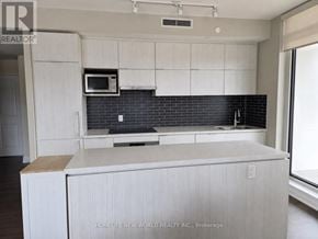 Markham (Unionville) condo for rent - A kitchen with white cabinets and a black backsplash.