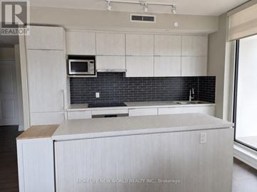 Markham (Unionville) condo for rent - A kitchen with white cabinets and a black backsplash.
