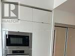Toronto (Waterfront Communities) condo for rent - A modern kitchen with a microwave oven built into the cabinetry.