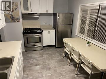 Vancouver apartment for rent - A kitchen with white cabinets and a tiled floor.