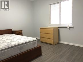 Vancouver apartment for rent - A bedroom with a bed, dresser, and window.