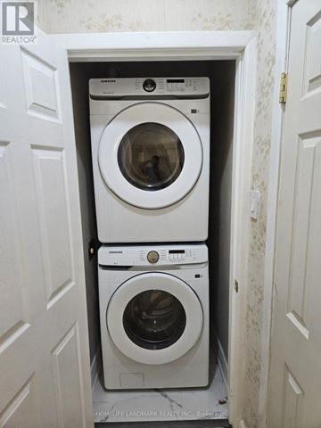 Toronto (Bendale) apartment for rent - A stack of three white washing machines in a small laundry room.