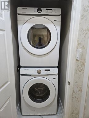 Toronto (Bendale) apartment for rent - A stack of three white Samsung washing machines in a small laundry room.
