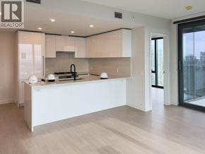 Burnaby apartment for rent - A modern kitchen with white cabinets and a large island.