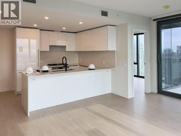 Burnaby apartment for rent - A modern kitchen with white cabinets and a large island.