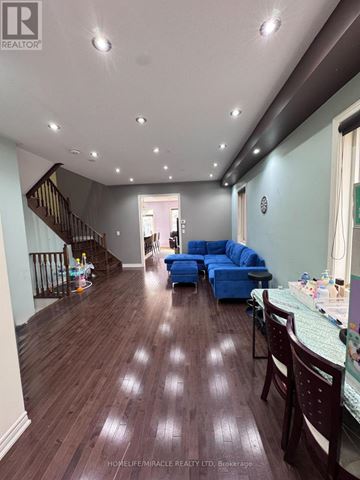 Brampton (Bram East) apartment for rent - A living room with a blue sofa and wooden floors.