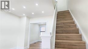 Windsor apartment for rent - A wooden staircase leads up to a window in a white room.