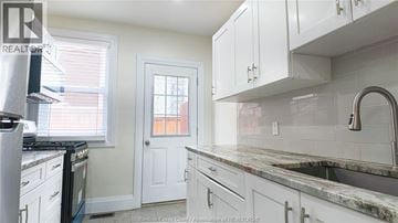 Windsor apartment for rent - A kitchen with white cabinets and a marble countertop.