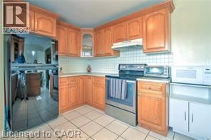 Brantford apartment for rent - A kitchen with wooden cabinets and a stove top oven.