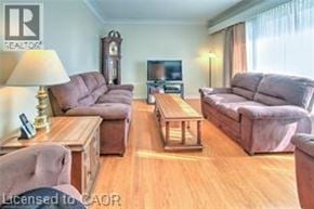 Brantford apartment for rent - A living room with a couch, chair, and television.