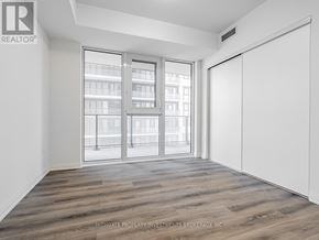 Vaughan (Vellore Village) condo for rent - A room with a sliding door and a window with a view of a building outside.