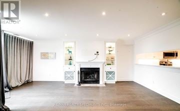 Vaughan (West Woodbridge) townhouse for rent - A living room with a fireplace and a painting on the wall.