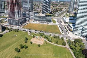 Mississauga (City Centre) condo for rent - An aerial view of a city with a large building under construction and a green park in the foreground.