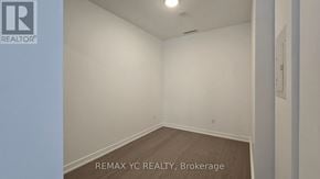Toronto (Forest Hill South) condo for rent - A room with a white wall and a wooden floor.