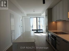 Toronto (Forest Hill South) condo for rent - A kitchen with white cabinets and a window with a view of a building outside.