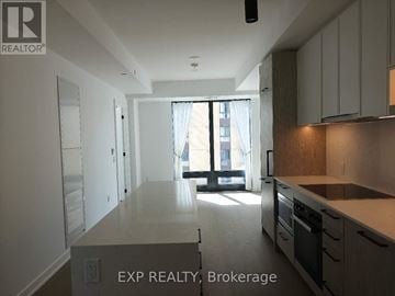 Toronto (Forest Hill South) condo for rent - A kitchen with white cabinets and a window with a view of a building outside.