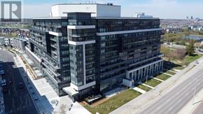 Oakville (Go Glenorchy) condo for rent - A large, modern building with many windows is the main focus of the image.