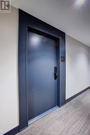 Oakville (Go Glenorchy) condo for rent - A blue door with a handle and a lock is in a room with grey carpet.