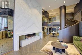 Oakville (Go Glenorchy) condo for rent - A living room with a marble fireplace and a green couch.