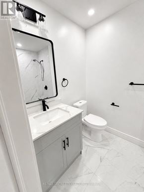 St. Thomas fourplex for rent - A white bathroom with a toilet, sink, and mirror.