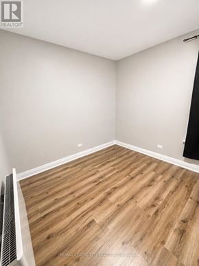St. Thomas fourplex for rent - A room with wooden flooring and a wall-mounted heater.