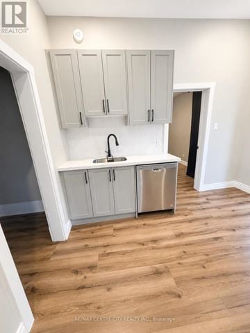 St. Thomas fourplex for rent - A kitchen with white cabinets and a wooden floor.