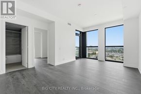 Toronto (Leaside) condo for rent - A spacious room with a view of the cityscape through large windows.