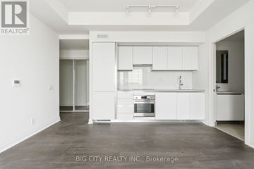 Toronto (Leaside) condo for rent - A spacious kitchen with white cabinets and a stainless steel oven.