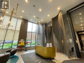 Toronto (Willowdale East) condo for rent - A reception area with a yellow reception desk and a glass wall.