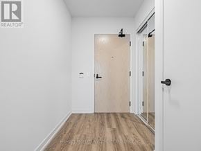 Vaughan (Vaughan Corporate Centre) condo for rent - A room with a wooden floor and white walls, with a door and a black handle.
