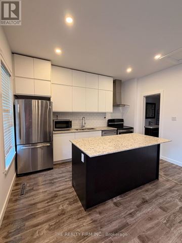 London East (East L) apartment for rent - A modern kitchen with a stainless steel refrigerator and a central island.