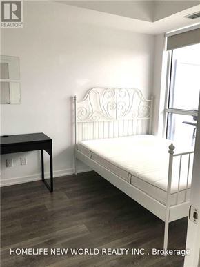Toronto (Henry Farm) condo for rent - A white metal bed frame in a room with a wooden floor.