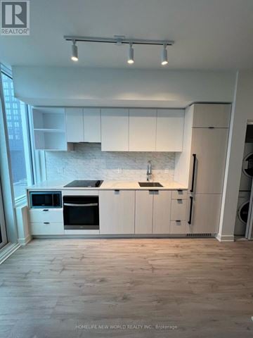 Toronto (Church-Yonge Corridor) condo for rent - A modern kitchen with white cabinets and a marble backsplash.