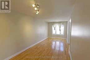 Barrie (Cundles East) apartment for rent - A room with wooden flooring and a window with curtains.