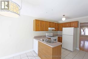 Barrie (Cundles East) apartment for rent - A kitchen with wooden cabinets and white appliances.