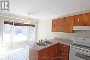 Barrie (Cundles East) apartment for rent - A kitchen with white appliances and wooden cabinets.