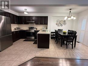 Brampton (Fletcher's Meadow) apartment for rent - A kitchen with a refrigerator, stove, and dining table.