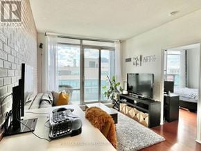 Mississauga (City Centre) condo for rent - A room with a bed, a couch, a television, and a window with a view of the city.