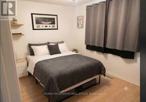 Barrie (Sunnidale) apartment for rent - A bedroom with a bed, nightstand, and a picture on the wall.
