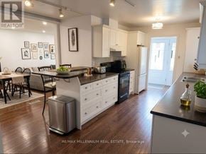 Barrie (Sunnidale) apartment for rent - A modern kitchen with white cabinets and a wooden floor.