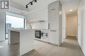 Toronto (Forest Hill South) condo for rent - A modern kitchen with white cabinets and a marble island.