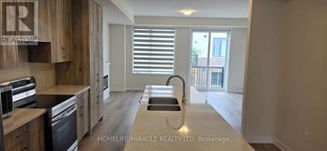 Oakville (Nw Northwest) townhouse for rent - A kitchen with wooden cabinets and a stainless steel dishwasher.