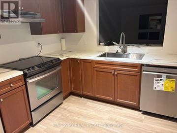 London South (South T) townhouse for rent - A kitchen with wooden cabinets and a stainless steel dishwasher.
