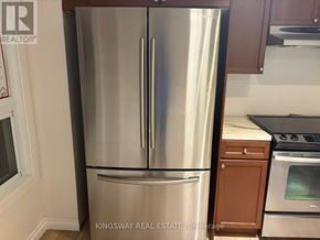 London South (South T) townhouse for rent - A stainless steel refrigerator in a kitchen with wooden cabinets.
