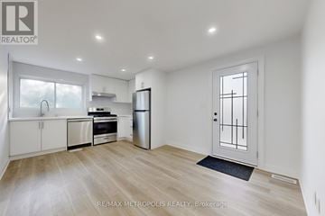 Toronto (Humber Summit) fourplex for rent - A spacious kitchen with white cabinets and stainless steel appliances.