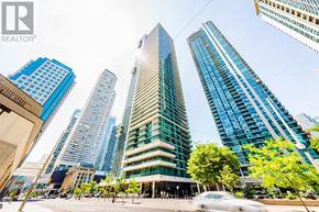 Toronto (Waterfront Communities) condo for rent - A cityscape with tall buildings and a car in the foreground.
