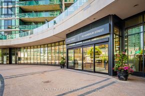 Toronto (Waterfront Communities) condo for rent - The entrance to a building with a glass facade and a sign that reads "18 Harbour Street".