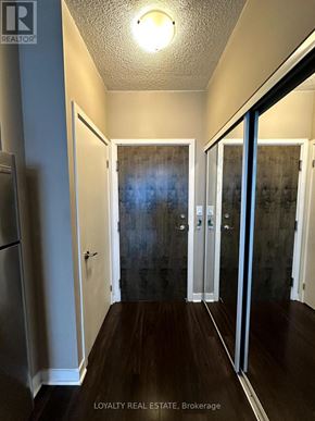 Toronto (Waterfront Communities) condo for rent - A hallway with a wooden floor and white walls.