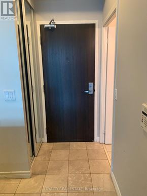Toronto (Waterfront Communities) condo for rent - A black door with a silver handle is in the middle of a hallway.